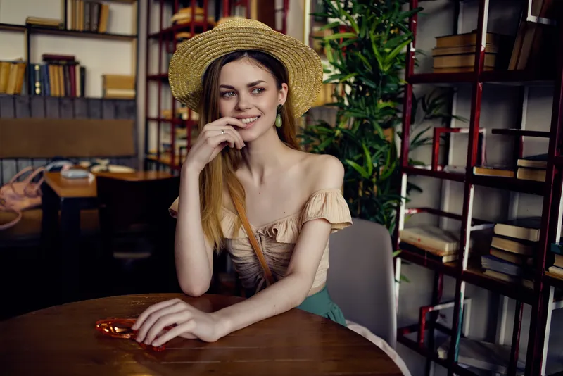 Симпатичная женщина читает книгу в кафе, отдыхая