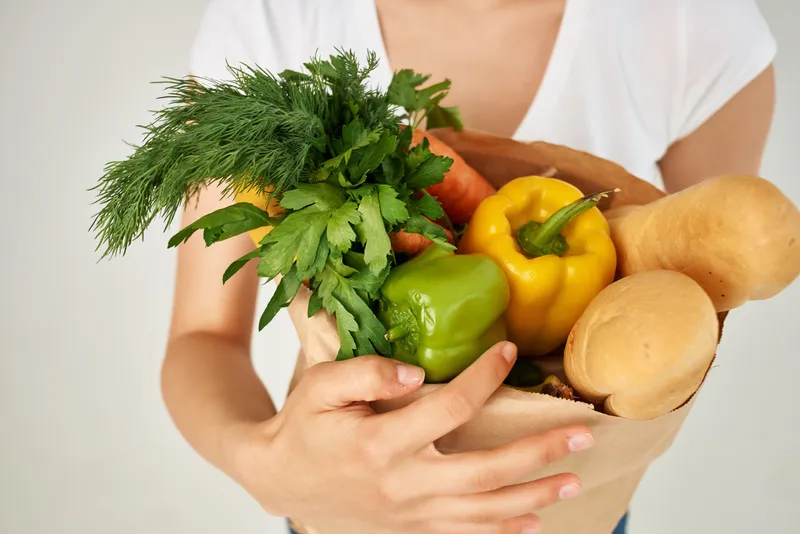 Женщина с пакетом продуктов в супермаркете, служба доставки