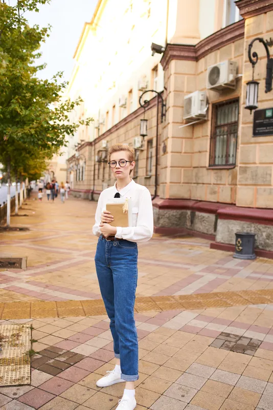 Женщина с короткой стрижкой держит в руках книгу на открытом воздухе, читает, образ жизни
