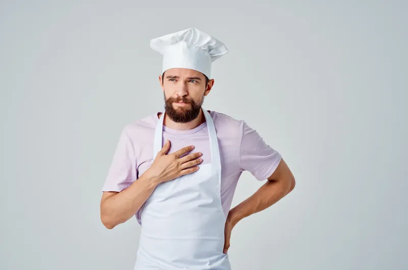 Профессиональный шеф-повар работает на кухне ресторана, занимаясь приготовлением блюд