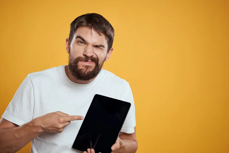 Мужчина с планшетом на жёлтом фоне, в белой футболке, новые технологии, бизнесмен, сенсорный экран, тачпад