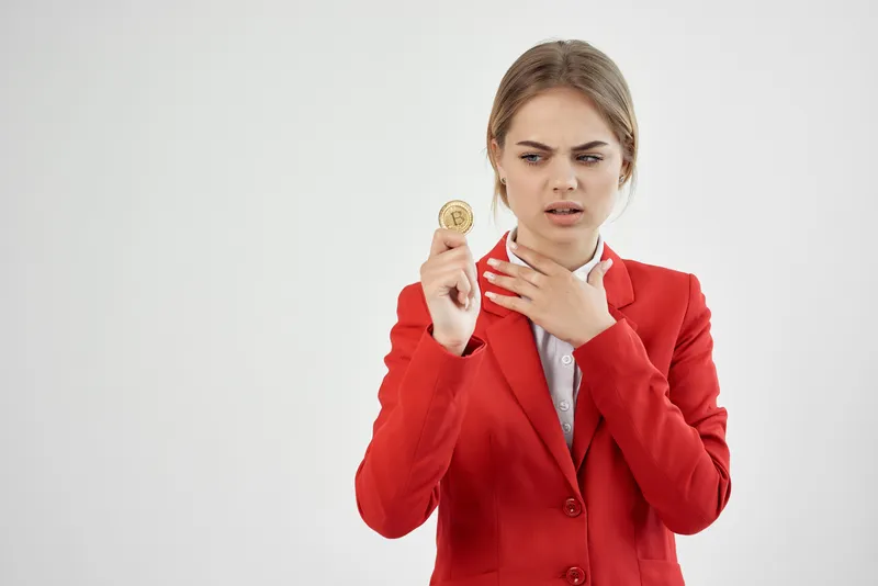 Бизнесвумен держит в руках биткоин, кадр обрезан
