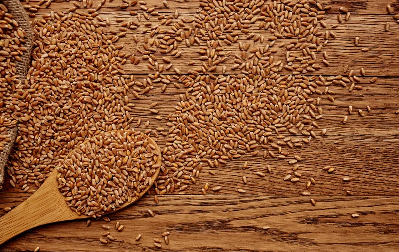 Пшеница в мешке на фоне деревянного стола, зерновые продукты, вид сверху