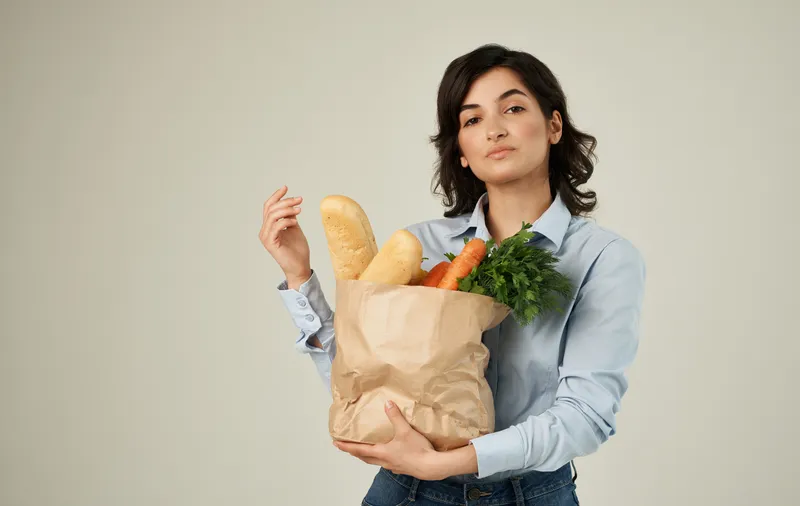 Весёлая симпатичная женщина в рубашке с пакетом продуктов для здорового питания, доставка еды на дом