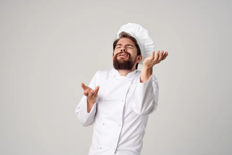 Шеф-повар занимается кулинарией в кулинарной индустрии, демонстрируя профессиональные эмоции
