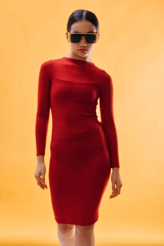 Woman in red dress and sunglasses poses confidently against yellow background with casual and stylish fashion look for modern elegance and attitude in studio photo.