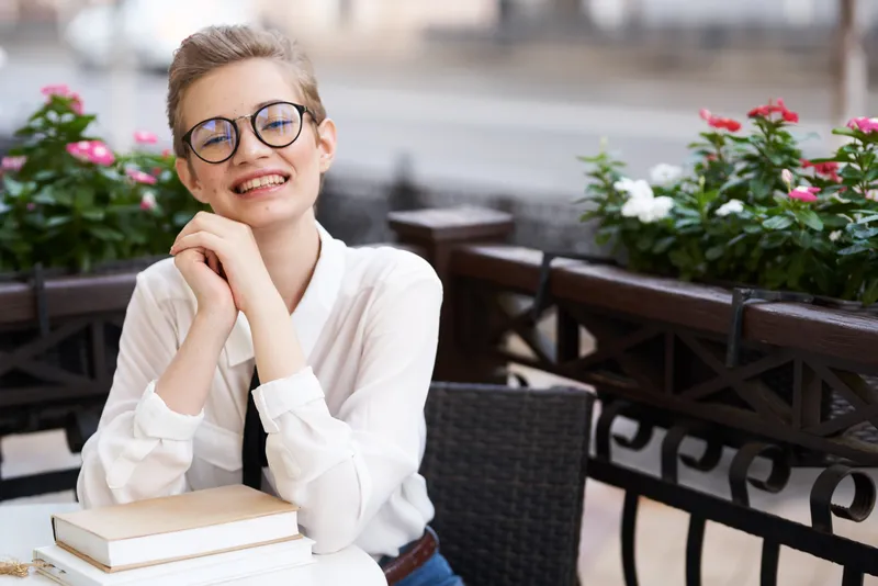 Студент с книгой в руках читает на прогулке на свежем воздухе