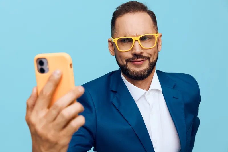 A professional business man on a solid colored background, exuding confidence and approachability with a calm, focused mood, depicted in a bold blue setting.