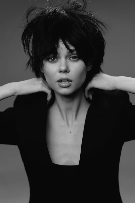 black and white portrait of a young woman with dark hair and intense expression wearing a black top