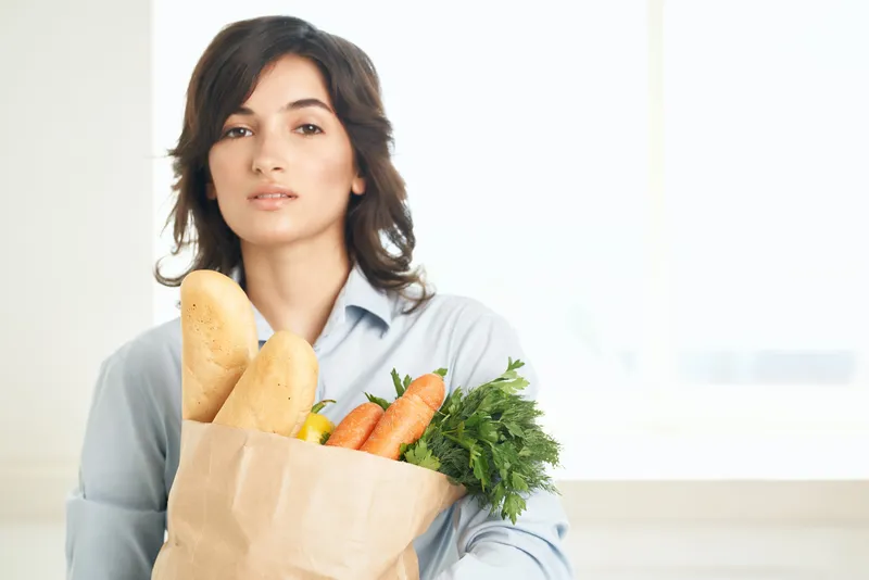 Брюнетка с букетом продуктов из овощей в супермаркете, кухня, приготовление еды