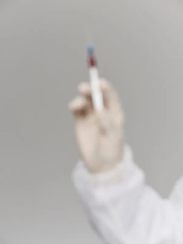 Рука в медицинской перчатке делает прививку вакциной от COVID-19 в условиях исследовательской лаборатории