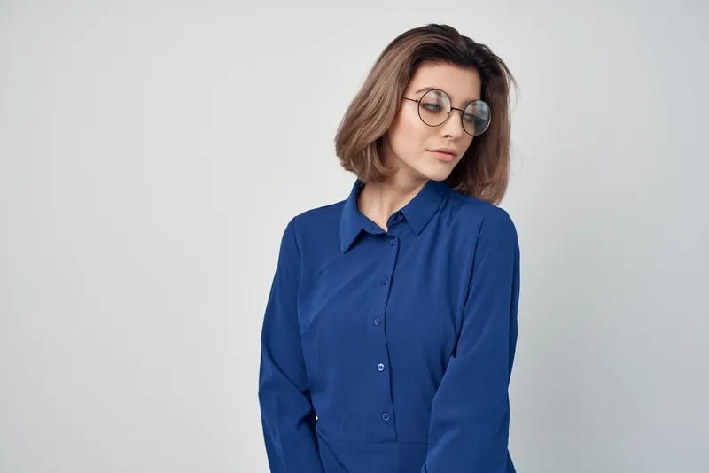 Деловая женщина в синей рубашке жестикулирует рукой, офисные профессионалы работают