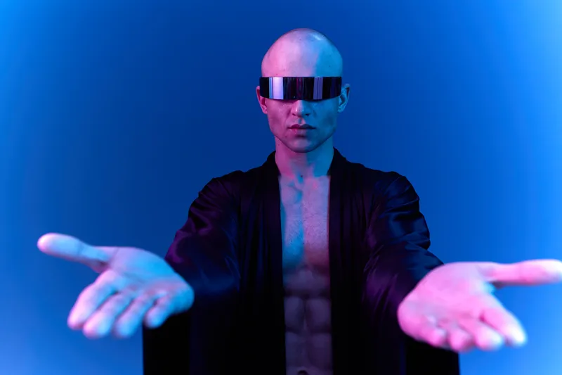 Futuristic man wearing sunglasses extends his hands, showcasing a striking blend of blue and purple lighting. The image creates a captivating ambiance and style.
