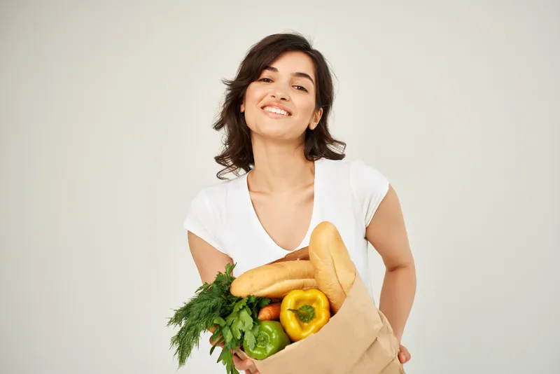 Брюнетка с пакетом продуктов, овощи, здоровая еда, студия