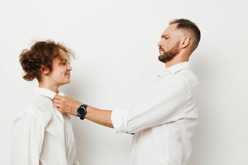 Professional man assists a colleague on an isolated colored background, expressing leadership, confidence, and positive emotions in a focused business moment.