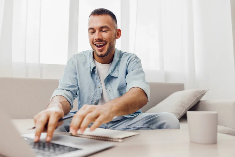 Happy man working from home embraces a balanced lifestyle while on a digital detox, exploring mental health and soft masculinity amidst modern challenges.
