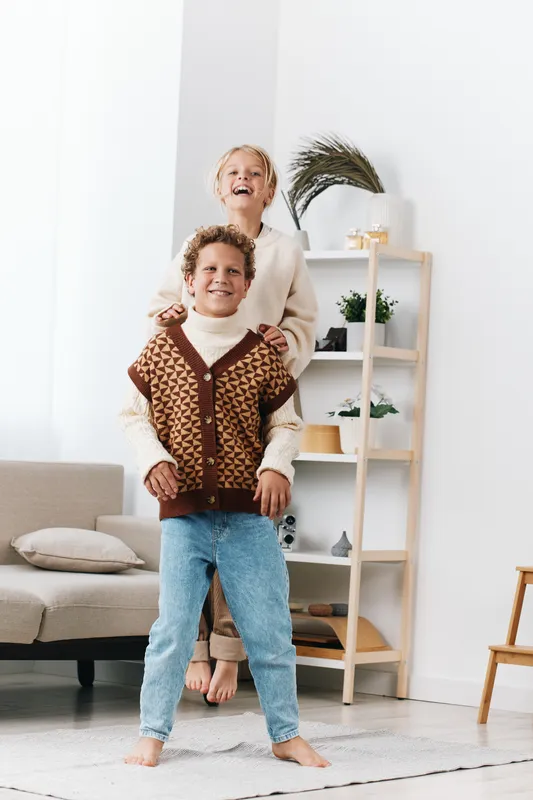 Authentic play scene shows children at home, smiling and active, engaging in warm, candid moments that blend imagination, school spirit, and everyday lifestyle.