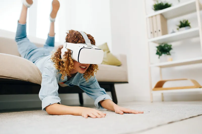 Виртуальная реальность: улыбающаяся женщина играет в игру дома в VR-очках, окруженная футуристическими цифровыми технологиями в современной домашней гостиной