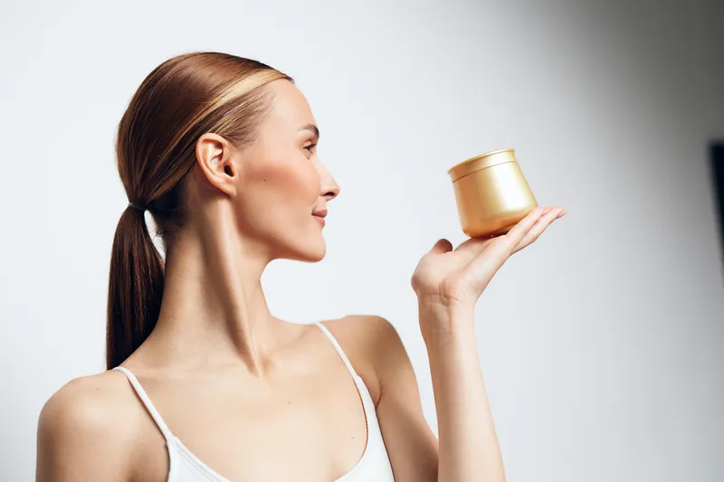 Woman in profile holding cup of coffee, tea, smiling, relaxed wellness and spa mood, morning drink aroma, clean white background, natural beauty portrait, soft light, steam