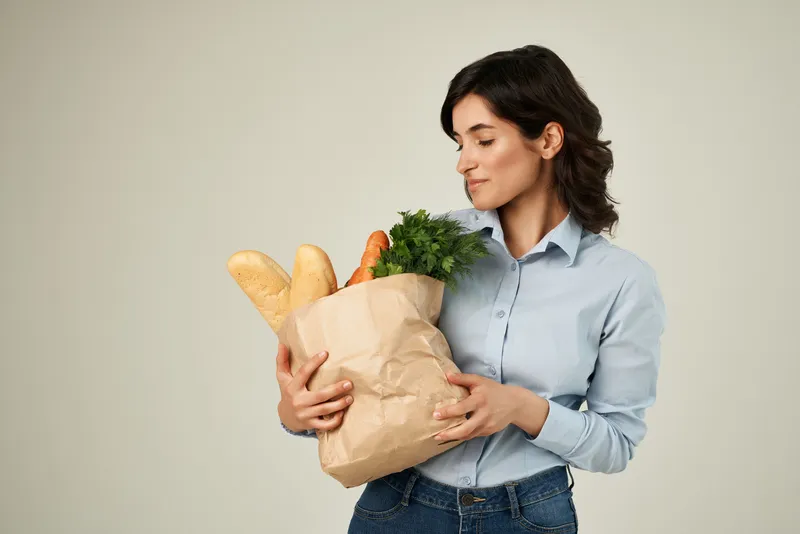 Женщина в синей рубашке упаковывает продукты в супермаркете, стиль жизни