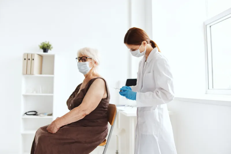 Пациент и врач, инъекция шприцем, паспорт вакцинации, лечение в больнице
