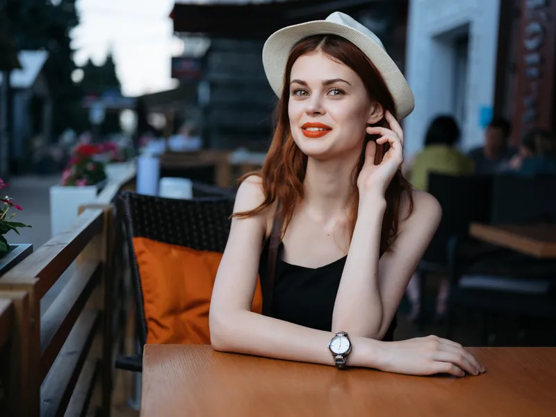 Женщина отдыхает в летнем кафе на открытом воздухе, общается за завтраком
