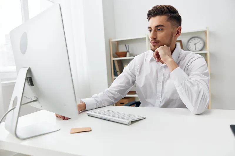 Бизнесмены сидят за столом перед компьютером с клавиатурой на рабочем месте