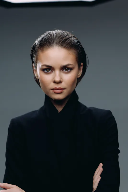 serious woman wearing black outfit with crossed arms looking confident and focused