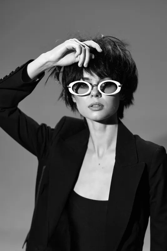 Black and white stylish woman wearing sunglasses and blazer with confident expression