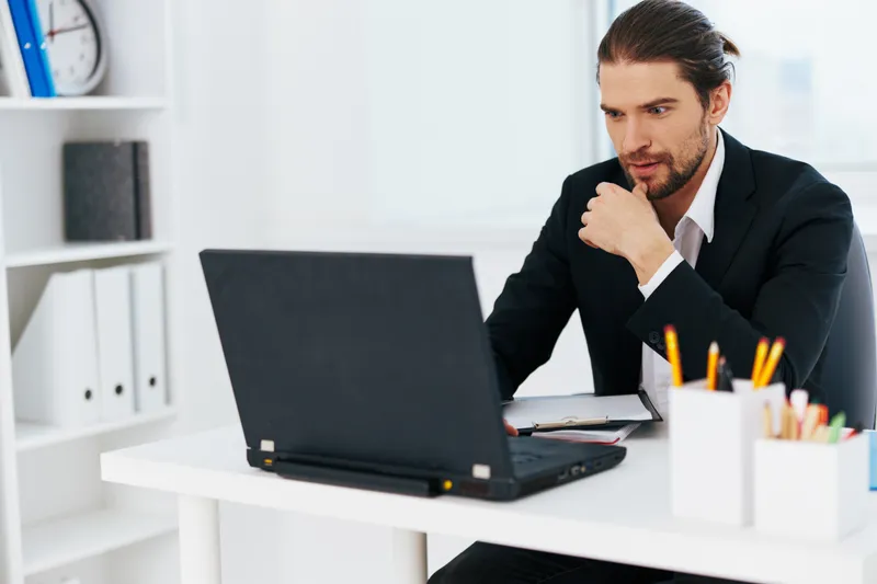 Менеджер работает в офисе с синей папкой для документов