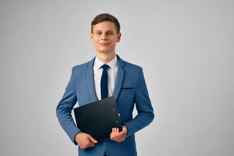 Привлекательный деловой мужчина в костюме с документами в руках, студийный менеджер