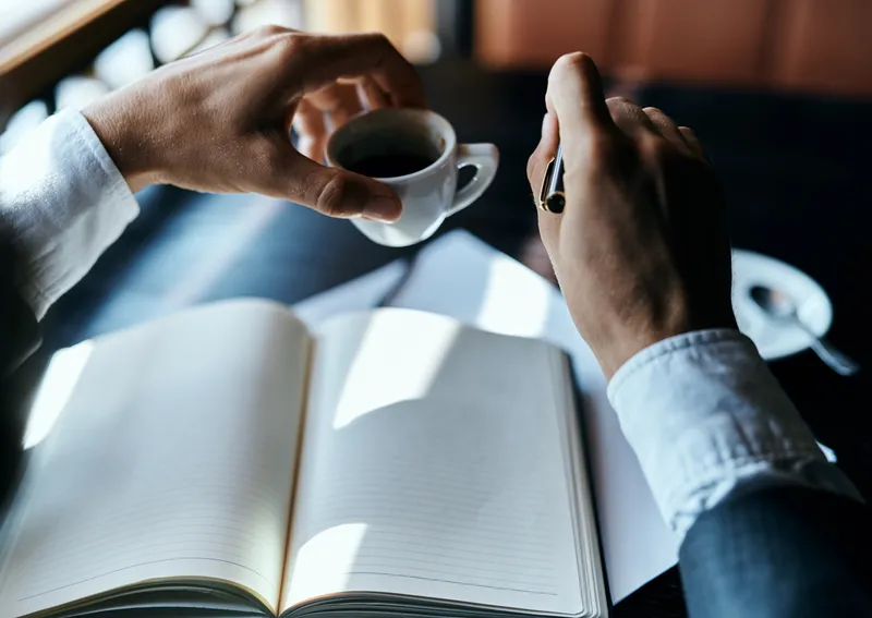 Бизнесвумен в кафе с книгой на столе, документами, чашкой кофе, работа и образ жизни
