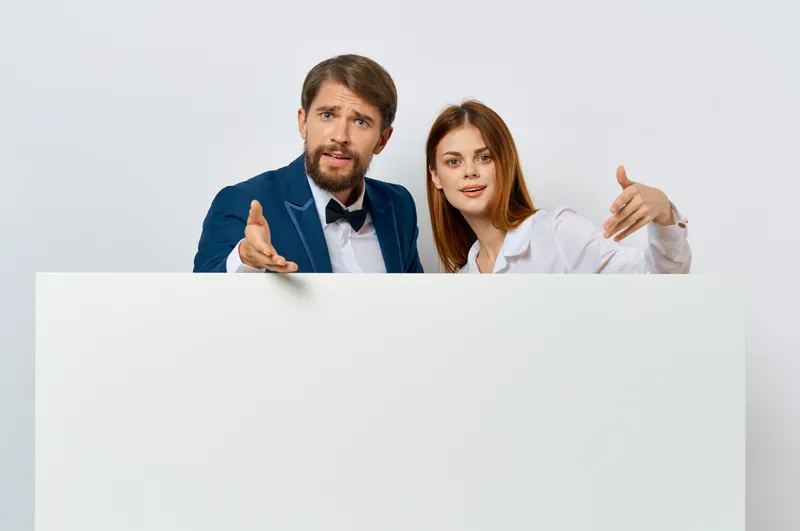 Мужчина и женщина на рекламном щите, маркетинг, веселые эмоции