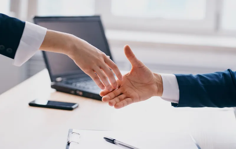 Деловые люди обмениваются рукопожатием на работе