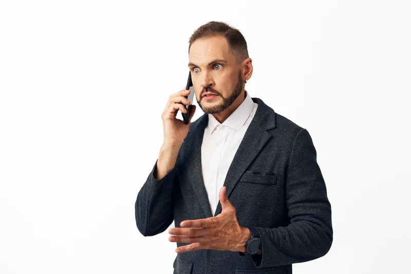 A professional businessman on an isolated colored background, speaking on a mobile phone with a calm yet confident expression, portraying focus, strategy, and leadership.