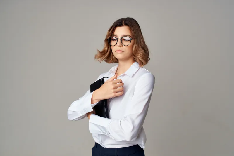 Деловая женщина в белой рубашке, офис-менеджер, позирует с документами