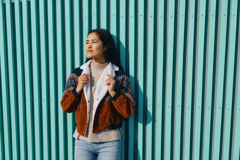 Jacket fashion and wall outdoor backdrop for urban style shoot, showcasing knit textile denim and casualwear with bold color texture and layered outfit ready for street trend storytelling