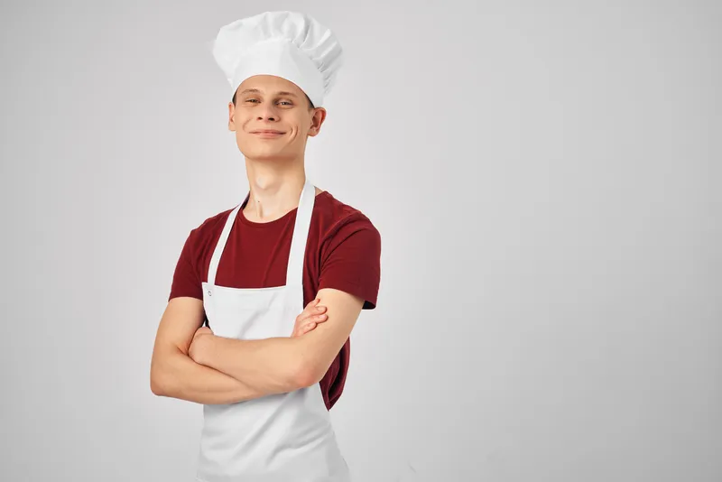 Мужчина-повар в профессиональной униформе работает в ресторане