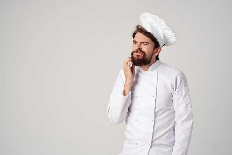 Бородатый мужчина-шеф-повар на кухне, жесты рук, профессиональные эмоции