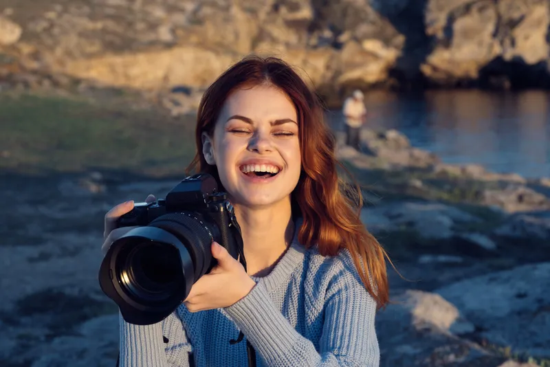 Симпатичная женщина-фотограф на природе в скалистых горах, приключение