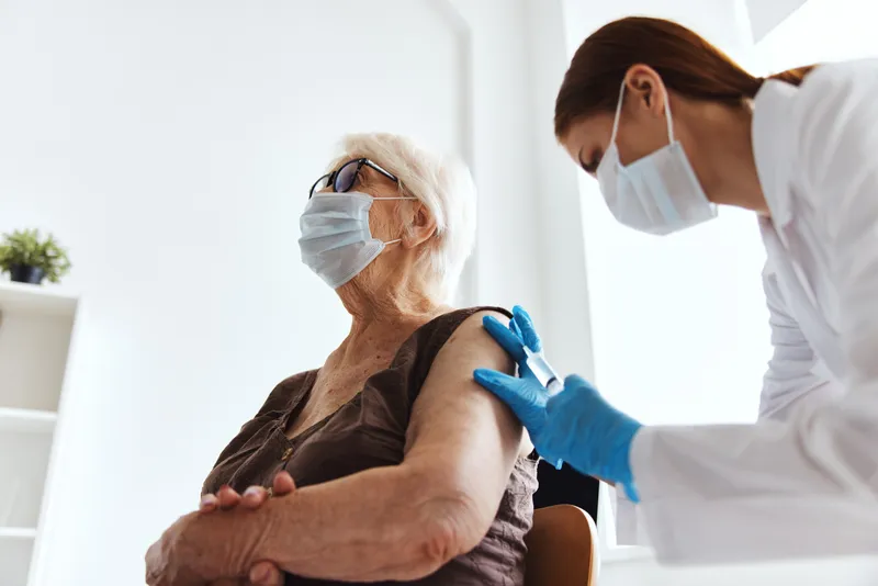 Пациент в больнице с вакцинным паспортом и инъекцией лекарства