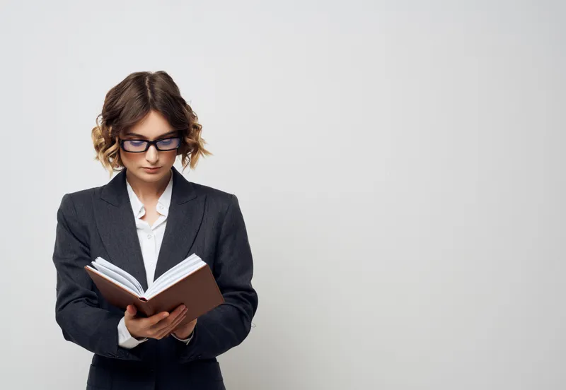 Женщина в очках с книгой в руках
