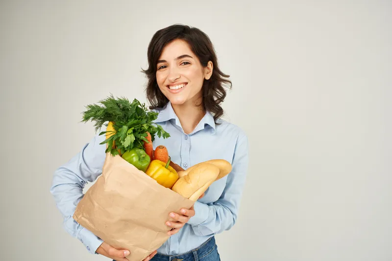Женщина с бумажным пакетом продуктов в супермаркете, стиль жизни