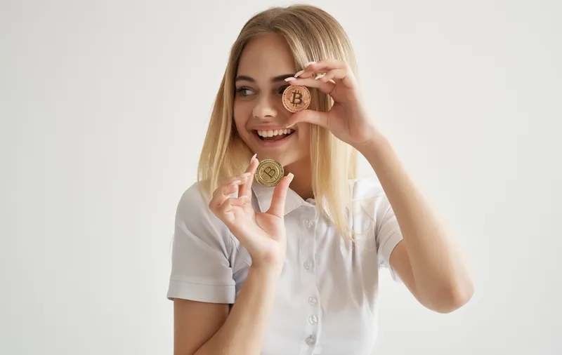 Симпатичная женщина держит в руках криптовалюту