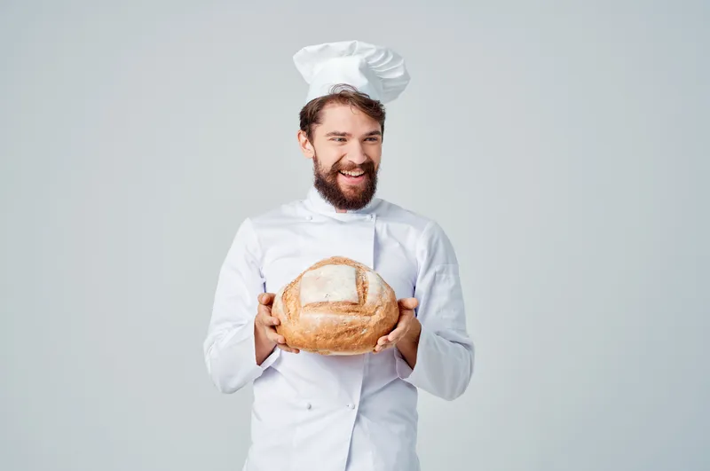 Пекарь на кухне, работа с хлебобулочными изделиями на изолированном фоне