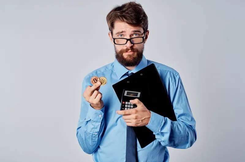 Мужчина-финансист в голубой рубашке занимается исследованием криптовалют, экономики и коммерции