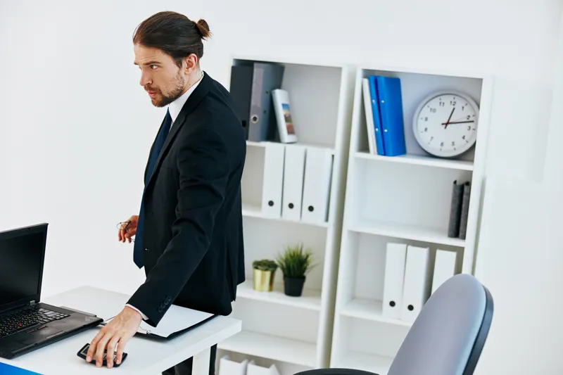 Мужчина в костюме работает с официальными документами в офисе