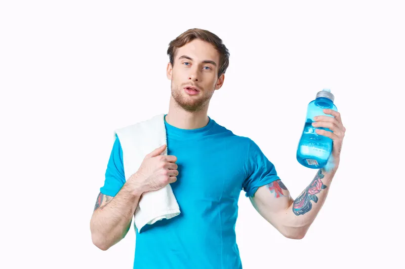 Спортсмен с полотенцем на плече и бутылкой воды, энергия, здоровье, тренировка