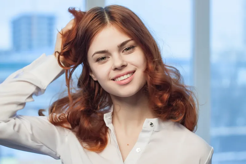 Симпатичная рыжеволосая женщина-менеджер в офисе — радость, профессионализм, эмоции