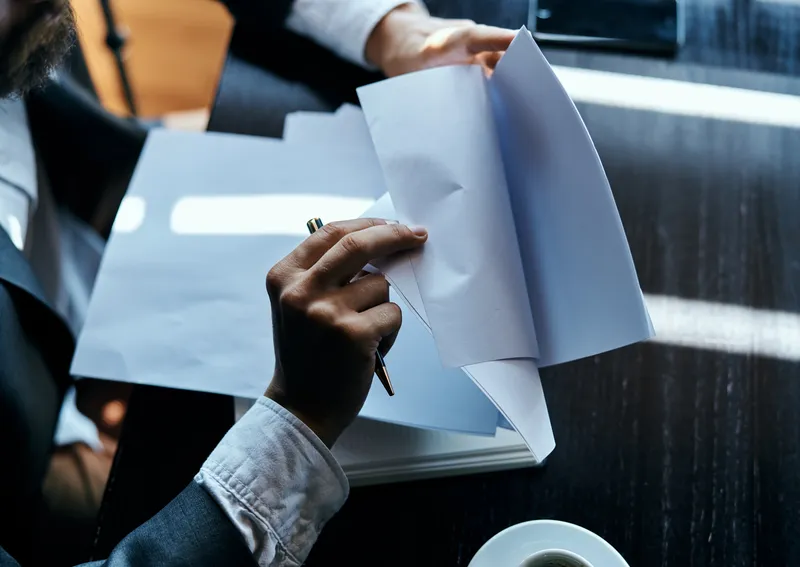 Бизнесмен в костюме сидит в кафе или с ноутбуком, работа — официальная